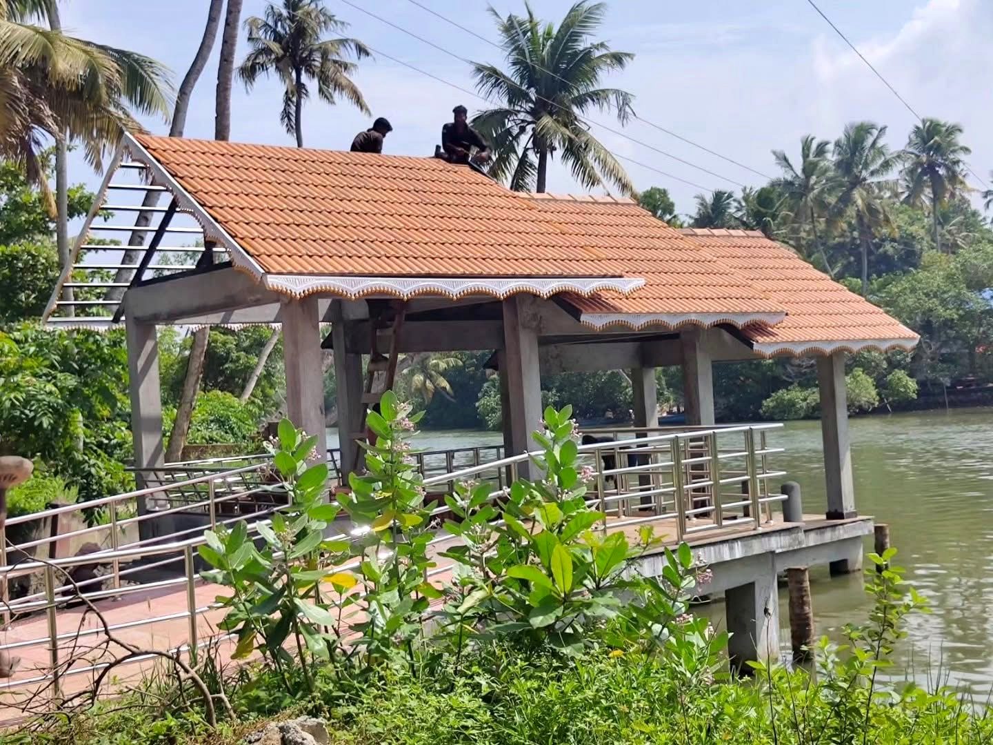 Boat jetty at Kayikkara Kadavu with workers laying the tiled roof